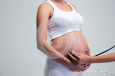 Pregnant woman being examine with stethoscope Stock Photo