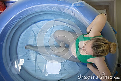 A pregnant woman in a birthing pool during a natural home birth Stock Photo