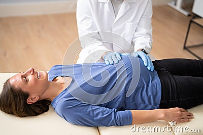 Pregnant Woman At Chiropractor. Baby Breech Physiotherapy Stock Photo