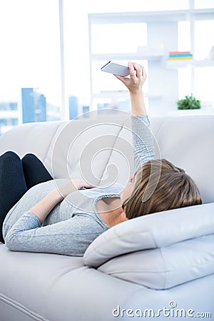 Pregnant woman clicking selfie using smartphone at home Stock Photo