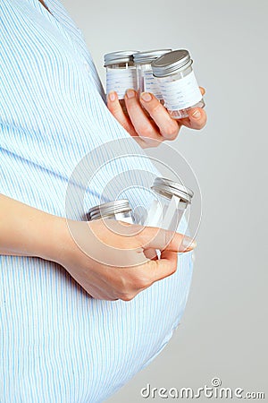 Pregnant woman with containers for urine samples Stock Photo
