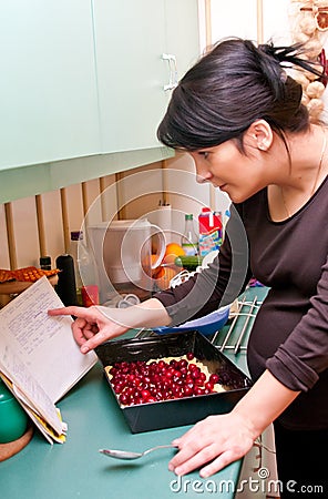 Pregnant woman cooking Stock Photo