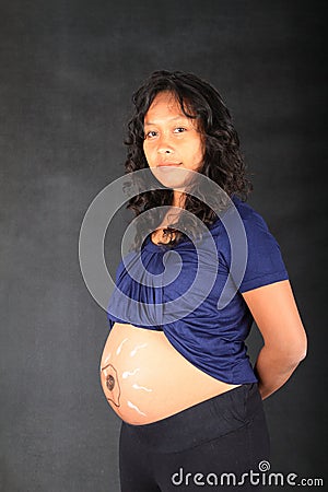 Pregnant woman with drawing of sperms reaching egg on belly Stock Photo