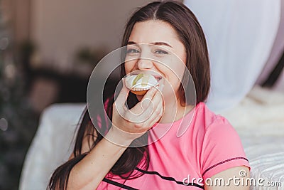 Pregnant woman eating cake smiling. Stock Photo