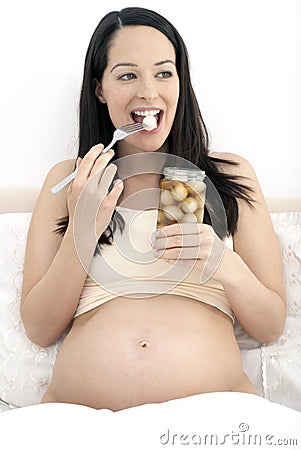 Pregnant woman eating pickled onions Stock Photo