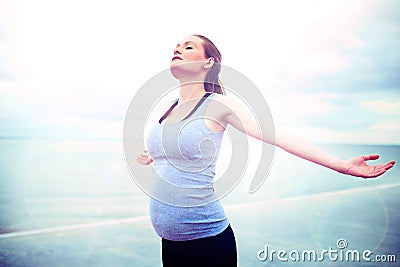 Pregnant woman embracing the sunshine Stock Photo