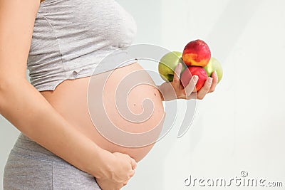 Pregnant woman with fruit in her hands. Vitamins for pregnant women. Vegetarianism. Useful products for pregnant women. Diet Stock Photo