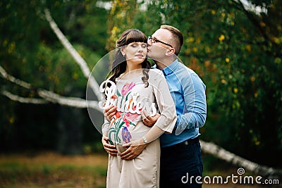 Pregnant woman and her handsome husband lovely relaxing on nature, have picnic in park. Stock Photo