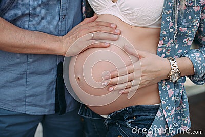 Pregnant woman and her husband put hands on the belly Stock Photo