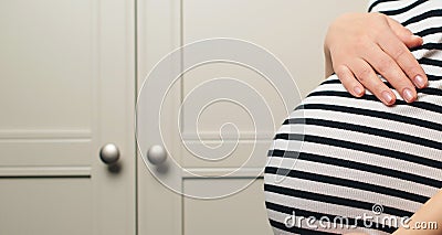 Pregnant woman holdig hands on belly, closeup. Pregnant woman's belly. Background with copy space Stock Photo