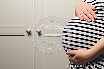 Pregnant woman holdig hands on belly, closeup. Pregnant woman's belly. Baby expectation Stock Photo