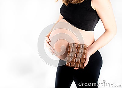 Pregnant woman holding a big dark chocolate bar. Gestational diabetes concept Stock Photo