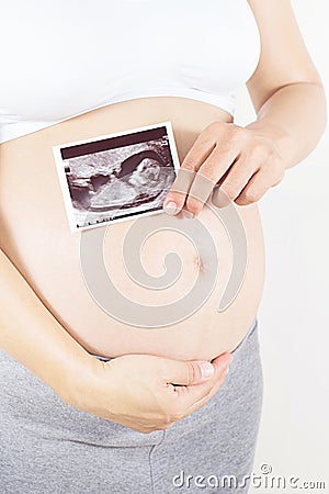 pregnant woman holding the digital echography photograph of her Stock Photo