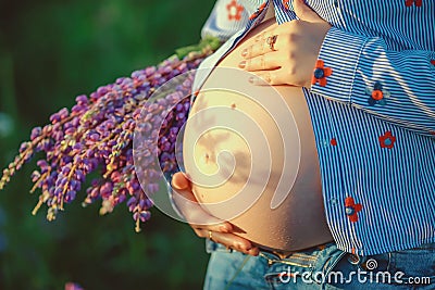 Pregnant woman holding her belly and flower - Love concept. Pregnancy concept Stock Photo