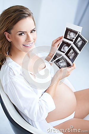 Pregnant woman holding her USG pictures Stock Photo