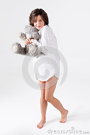 Pregnant woman holding soft toy. Pretty young woman carrying teddy bear. Stock Photo