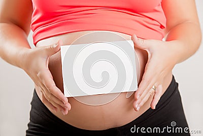 Pregnant Woman Holding a White Card Stock Photo