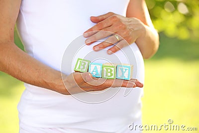 Pregnant woman holding word baby Stock Photo