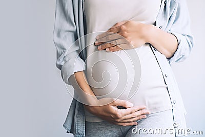 Pregnant woman holds hands on belly. Photo of pregnancy Stock Photo