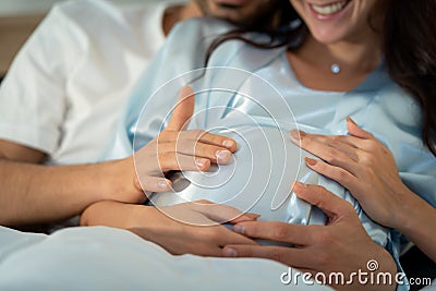 Pregnant woman with husband in bedroom with the atmosphere of having fun talking Stock Photo