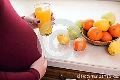 Healthy nutrition and diet during pregnancy. Cute young pregnant woman with glass of fresh juice Stock Photo