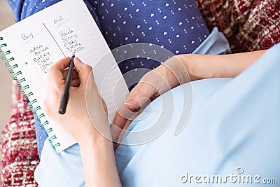 Pregnant woman listing baby names Stock Photo