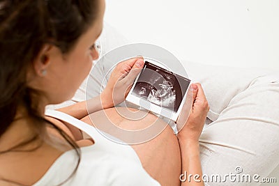 Pregnant woman looking at baby ultrasound scan Stock Photo