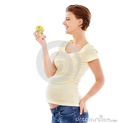 Healthy diet for the baby. A pregnant woman looking at a crunchy green apple while isolated on a white background. Stock Photo