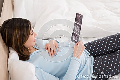 Pregnant Woman Looking At Ultra Sound Image Of Baby Stock Photo