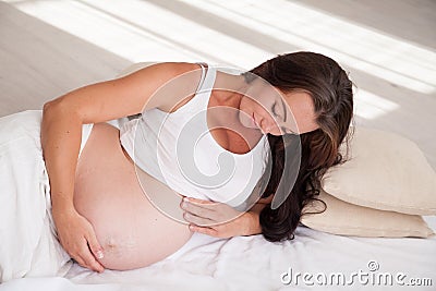 A pregnant woman is lying in bed waiting for the birth of a child Stock Photo