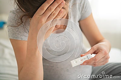 Pregnant woman making test. Close up of fingers holding express antigen covid test, negative result Stock Photo