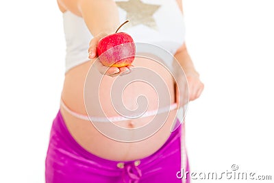 Pregnant woman measuring belly and holding apple Stock Photo