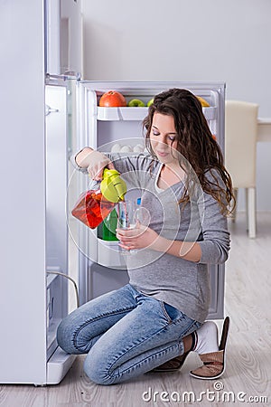 The pregnant woman near fridge looking for food and snacks Stock Photo