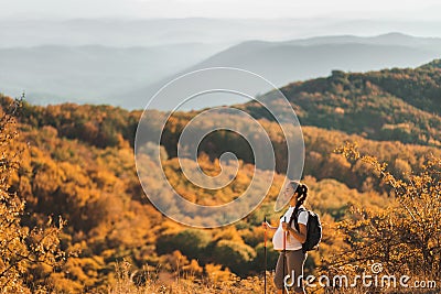 Pregnant woman nordic walking with trekking sticks with beautiful mountain view Stock Photo