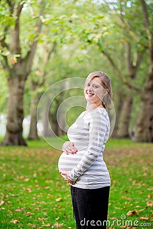 Pregnant woman playing yoga at the Hyde Park, London Stock Photo