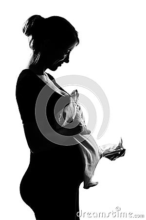 Pregnant woman portrait holding baby clothes Stock Photo