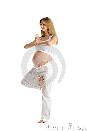 Pregnant woman practicing yoga, standing Stock Photo