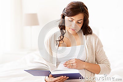 Pregnant woman reading book at home bedroom Stock Photo