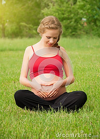 Pregnant woman is resting and relaxing on nature Stock Photo