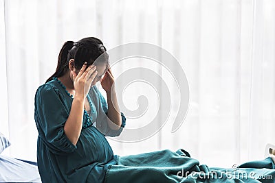 Pregnant woman Sitting in the patient`s bed Have headache Stock Photo