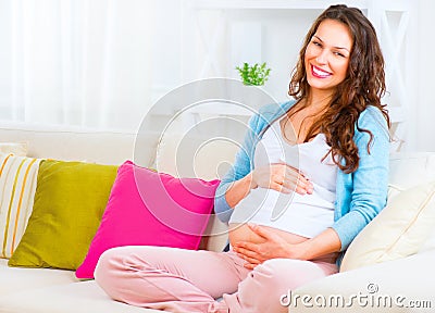 Pregnant woman sitting on a sofa Stock Photo