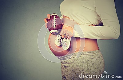 Pregnant woman with small shoes for unborn baby on belly Stock Photo