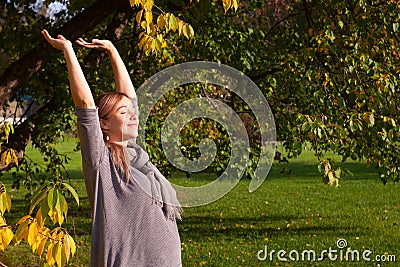 Pregnant woman stretching early in morning outdoor. Profile of young expectant female reaching for sun. Enjoy nature, peacefulness Stock Photo