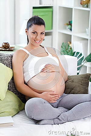 Pregnant woman stroking in her belly Stock Photo