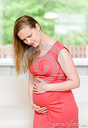 Pregnant woman with strong pain of stomach Stock Photo