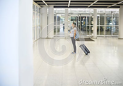 Pregnant woman with suitcase at airport or station Stock Photo