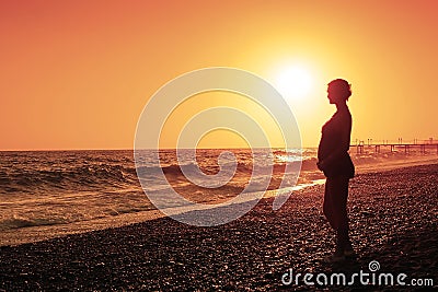 Pregnant woman and sunset Stock Photo