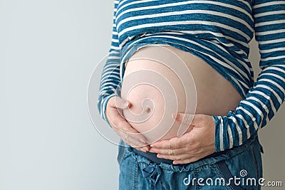 Pregnant woman touching and rubbing her belly Stock Photo