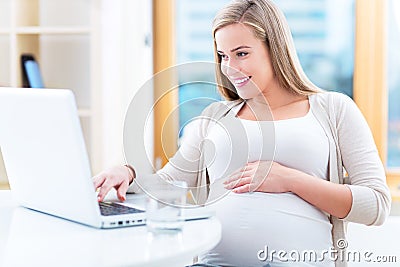 Pregnant woman using laptop Stock Photo