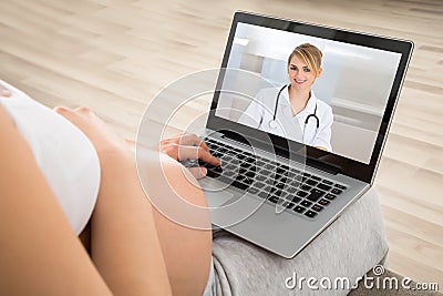 Pregnant Woman Videoconferencing With Doctor On Laptop Stock Photo